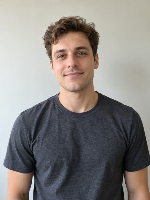 Photo of a man with brown wavy hair in a charcoal T-shirt